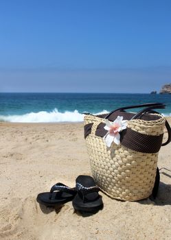 Sea time - seacoast, straw beach bag and flip-flops
