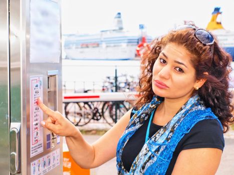 Unhappy brune, female, at ticket vending machine