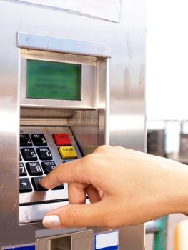 Woman entering PIN on a ticket vending machine