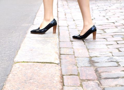 Female stepping onto the sidewalk in a street