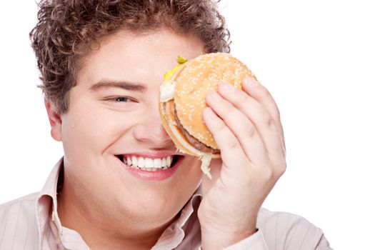 Young chubby man holding hamburger, isolated on white
