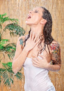 young woman with tattoos under shower
