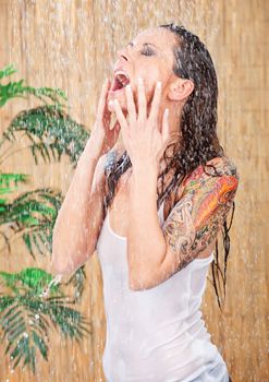 young woman in white shirt with tattoo on her hand under shower