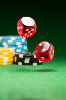 Rolling red dice on a casino table with chips