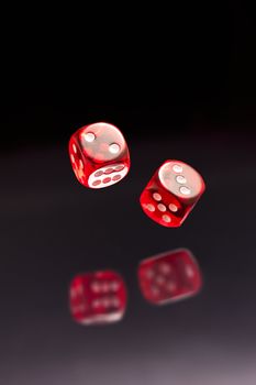 Rolling red dice over black grey background