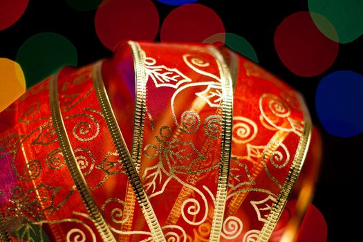A beautiful red ribbon with several light in the background  of diferent colors