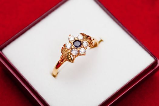 Fantastic gold ring adorned with one blue  and several white zirconia