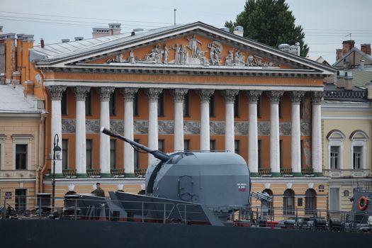 Cannon warship in the background of a historic building, the English Embankment in St. Petersburg