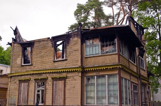 Abandoned old wooden retro house with burnt roof.