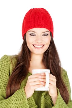 young happy brunette woman in wool sweater and cap holding a teapot, isolated on white