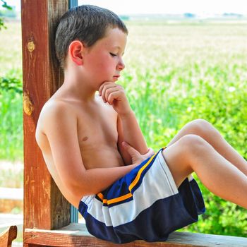 Cute little boy resting after playing hard on a hot day.