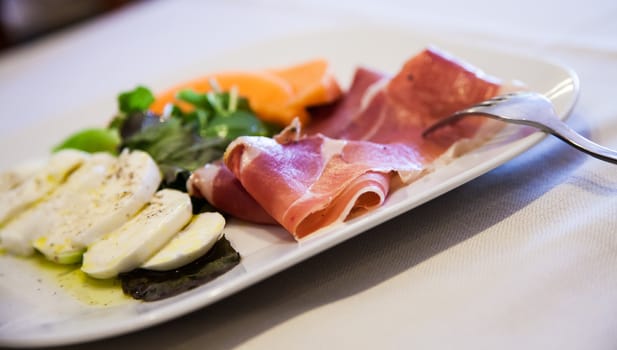 Italy, the best restaurant in Florence.  Ham, mozzarella and vegetables on the restaurant table.