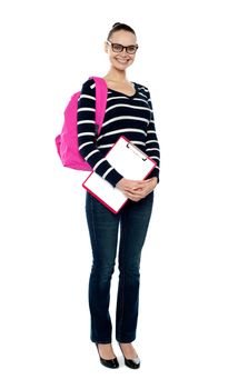 Full length portrait of a college student smiling at camera carrying school bag