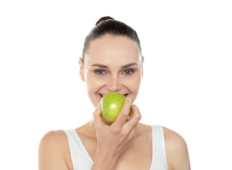Attractive girl eating fresh juicy green apple. Close up portrait