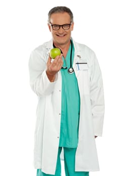 An apple a day keeps the doctor away. Doctor holding fresh green apple