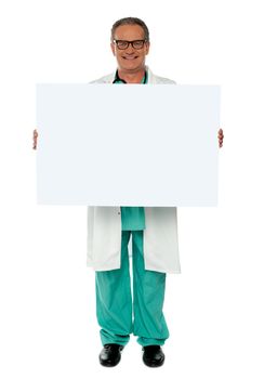 Senior medical professional displaying white blank banner ad to camera