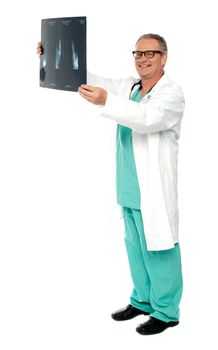 Full length shot of smiling surgeon holding x-ray report of a patient