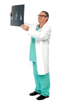 Full length portrait of senior surgeon holding x-ray report a patient