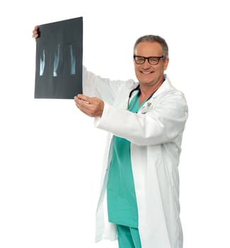 Smiling doctor in glasses reviewing x-ray report of a patient