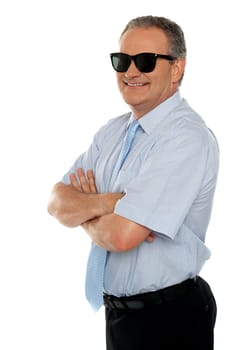 Confident male executive wearing sunglasses and posing with his arms crossed