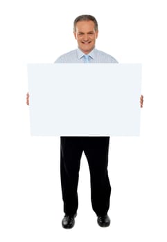Full length portrait of confident businessman holding blank billboard isolated over white