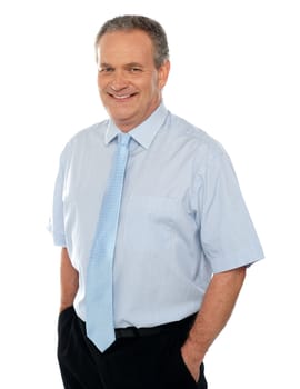 Casual business executive with hands in pocket smiling at camera