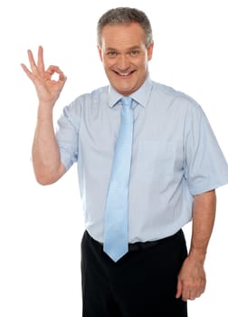 Cheerful male executive showing okay sign to camera. Isolated on white background