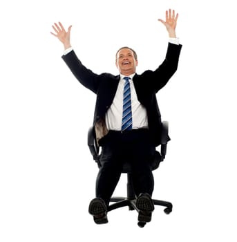 Excited businessman celebrating his success. Arms raised in air.