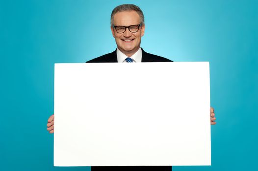 Business representative holding blank ad board and smiling at camera