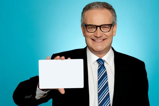 Businessman wearing glasses showing blank white placard to camera