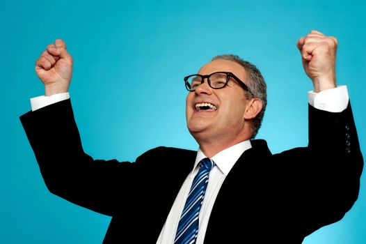 Portrait of a successful businessman with his hands raised against gradient background