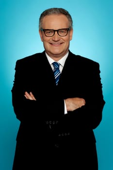 Smiling businessman posing with crossed arms looking at you