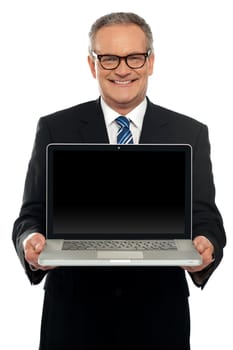 Senior executive standing with open laptop isolated against white background