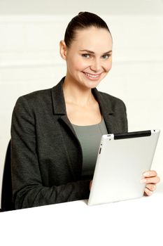 Corporate lady using wireless tablet device at her work desk