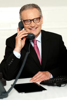 Smiling aged man communicating with his client while looking at camera
