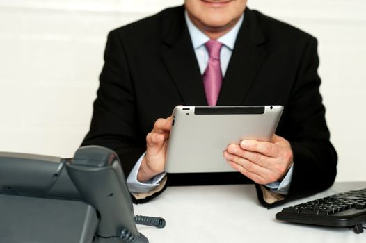 Cropped image of businessman using tablet pc in office