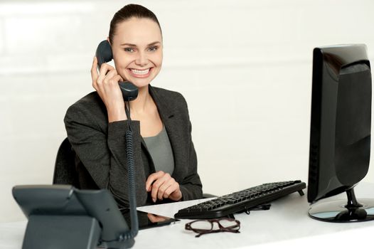 Cheerful secretary advising her client over a phone call isolated against white background