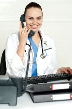 Medical expert communicating on phone and smiling at camera