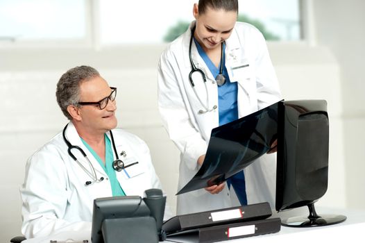 Team of two doctors reviewing x-ray report of a patient in lab