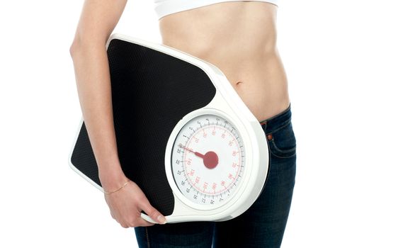 Closeup shot, woman carrying weighing machine. Cropped image