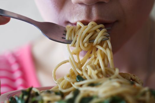 Beautiful young women are eating spaghetti in spicy