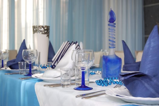 Everything is executed in is white blue color.
Wineglass and napkin in restaurant.