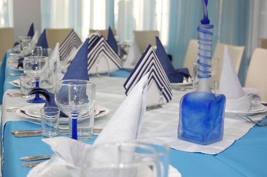 Everything is executed in is white blue color.
Wineglass and napkin in restaurant.