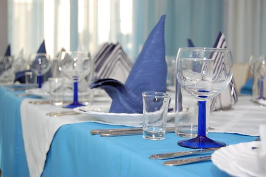 Everything is executed in is white blue color.
Wineglass and napkin in restaurant.