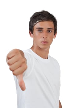 young swarthy man with brown eyes gives the thumbs down gesture on grey background