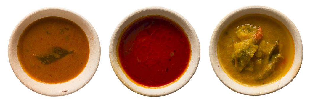 close up of bowls of indian curries isolated on white