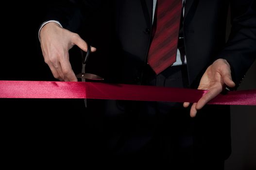 man in a business suit, cut red tape