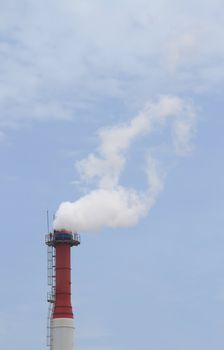 Plant pipe with smoke against blue sky
