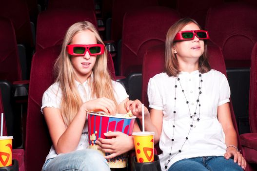 two girls watching a movie at the cinema