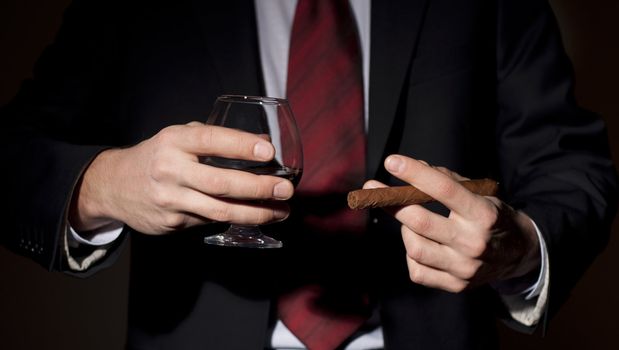 rich person, holds a cigar and whisky